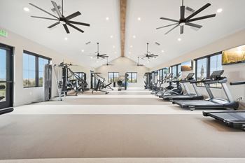 A spacious gym with treadmills, exercise bikes, and other equipment.